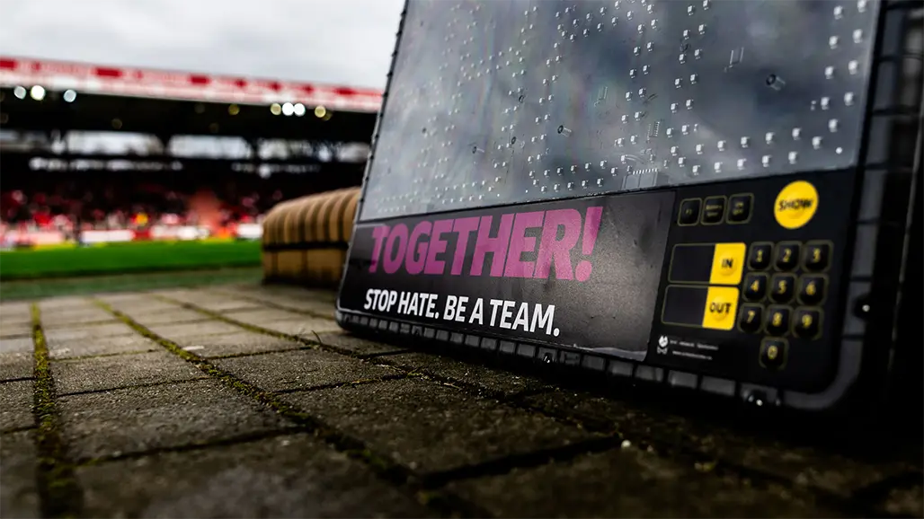 Die "TOGETHER! STOP HATE. BE A TEAM."-Logo auf einer Schautafel. (Foto)