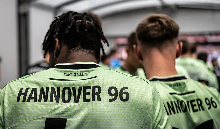 Two players from Hannover 96 in the tunnel to the field with their backs to the camera. (Photo)