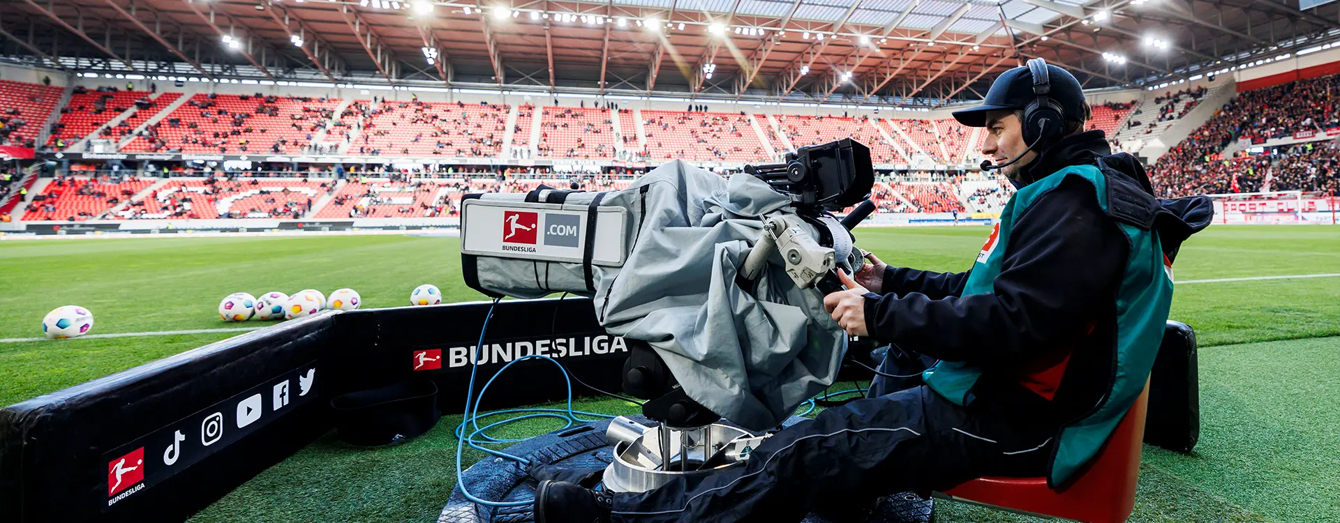 A camera man on a swivel chair guiding the camera on the field sideline. (Photo)