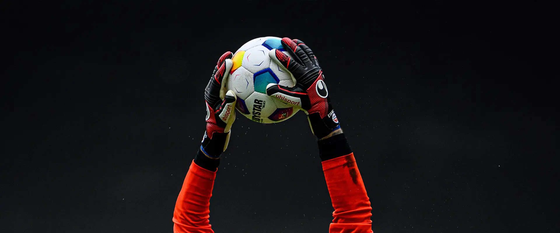 A close-up of a goalkeeper catching the football. (Photo)