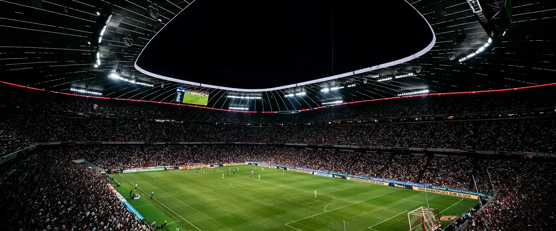 A full stadion at night with an ongoing game, viewed from the top ranks. (Photo)
