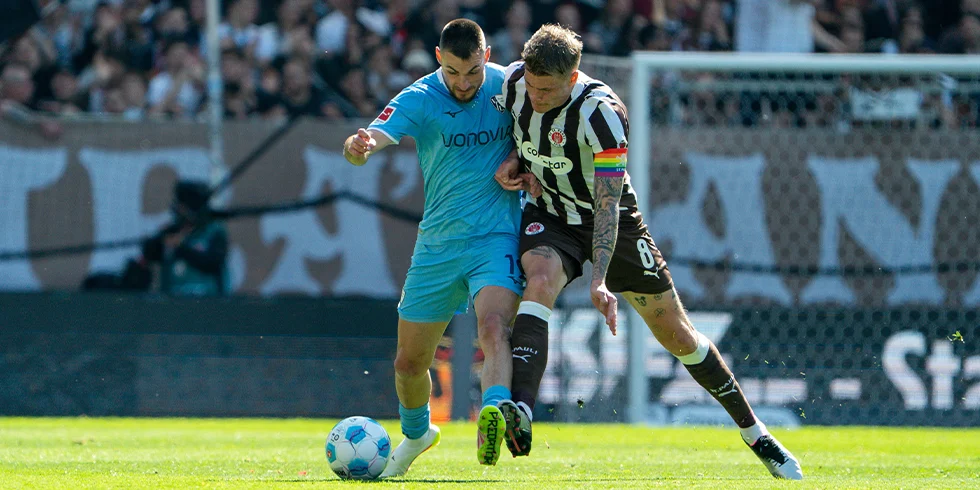 Anthony Losilla vom VfL Bochum im hellblauen Trikot und Eric Smith vom FC St. Pauli üben für den dreibeinigen Wettlauf. (Foto)