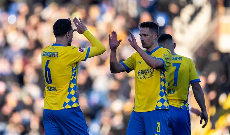 Zwei Spieler von Eintracht Braunschweig sind im Begriff, sich abzuklatschen. (Foto)