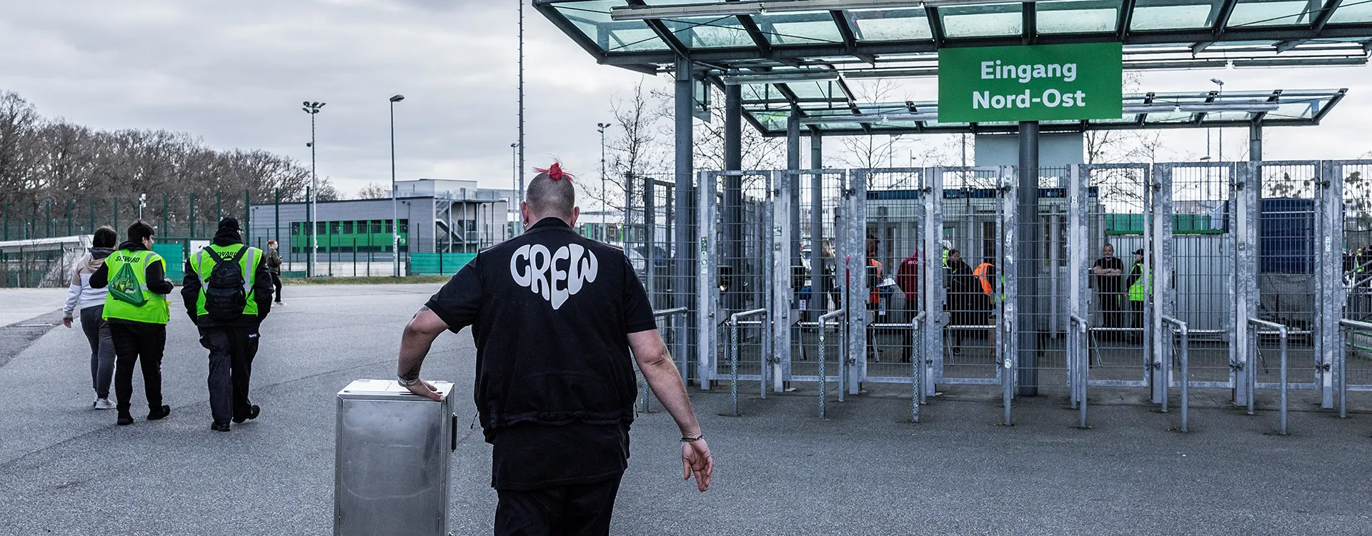 Ein Mann mit dem Aufdruck „Crew“ schiebt einen silbernen Kasten. (Foto)