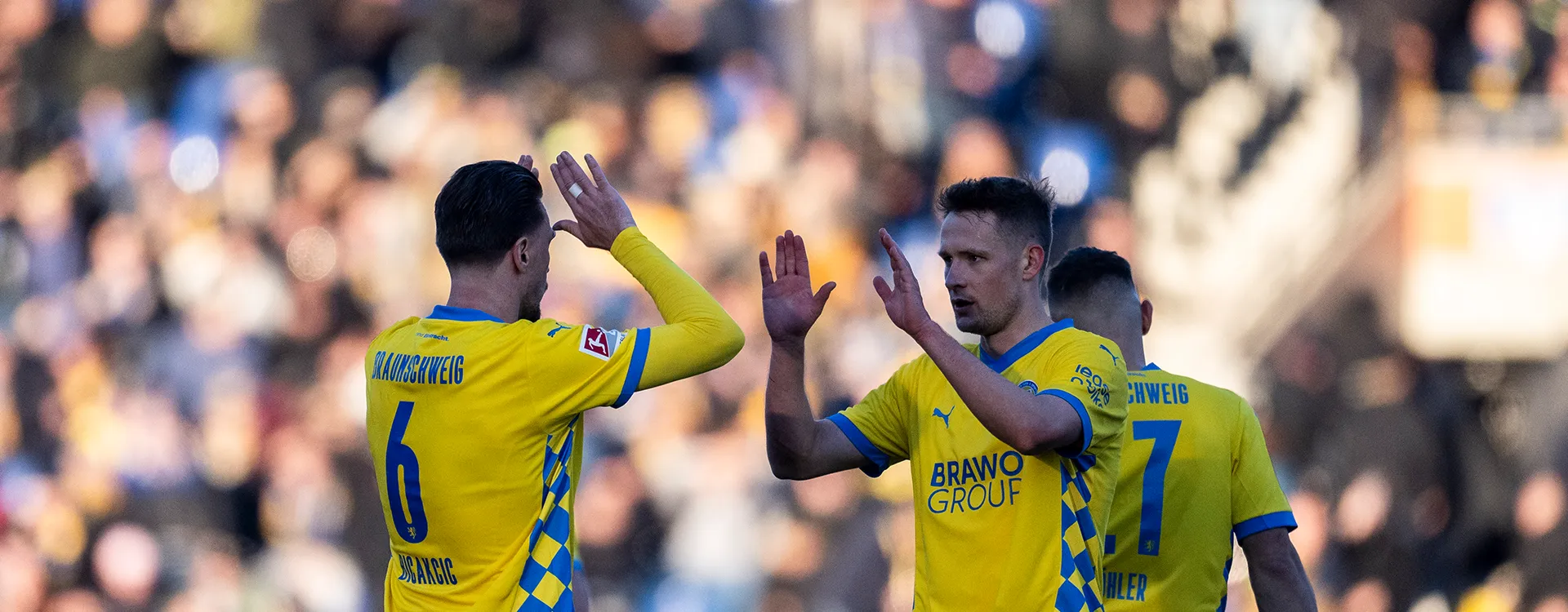 Two players from Eintracht Braunschweig are about to high-five each other. (Photo)